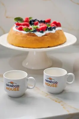 a cake on a plate with two coffee cups at Orinoco Sunset House I - Private Jacuzzi in Calheta