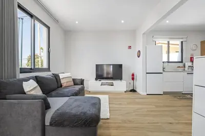 a living room with a couch and a tv at Orinoco Sunset House I - Private Jacuzzi in Calheta