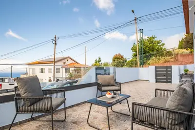 a patio with chairs and a table on a balcony at Orinoco Sunset House I - Private Jacuzzi in Calheta