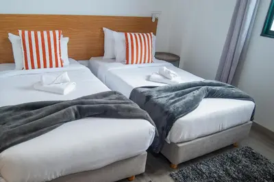 two beds with blankets and pillows in a room at Apartment II Estrela da Calheta in Calheta