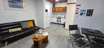 a living room with a couch and a table and a kitchen at Apartment II Estrela da Calheta in Calheta