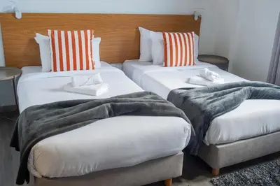 two beds in a hotel room with blankets and pillows at Apartment II Estrela da Calheta in Calheta