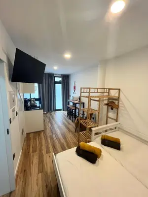 a bedroom with two beds and a dining room at Modern Studio Flat in Machico in Machico