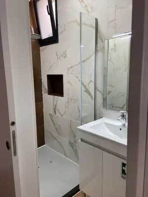 a white bathroom with a shower and a sink at Modern Studio Flat in Machico in Machico