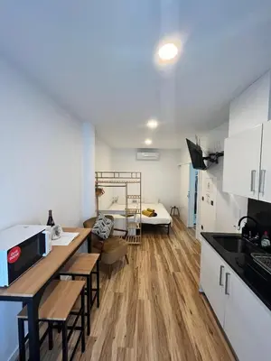 a kitchen and living room with a bed in the background at Modern Studio Flat in Machico in Machico