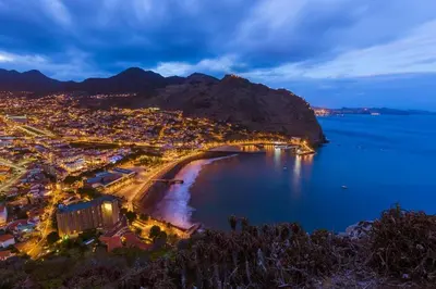 an aerial view of a city and a beach at night at Modern Studio Flat in Machico in Machico
