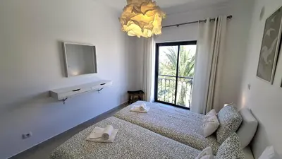 a bedroom with a bed and a tv and a window at Apartamento Magnólia in Lagos