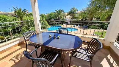 a table and chairs on a balcony with a pool at Apartamento Magnólia in Lagos