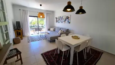 a living room with a table and a couch at Apartamento Magnólia in Lagos