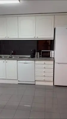 a kitchen with white cabinets and a white refrigerator at Seavale Apartement in Funchal