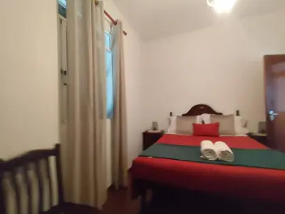 a bedroom with a red bed with shoes on it at Três Marias - Shared Countryside Connection in Lanceiros