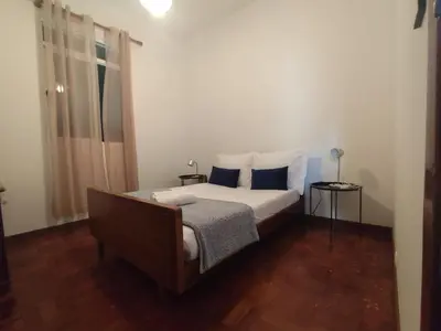 a bedroom with a large bed with blue pillows at Três Marias - Shared Countryside Connection in Lanceiros