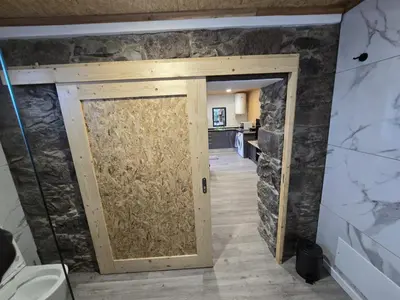 a door in a room with a stone wall at casa Farraia in Santana