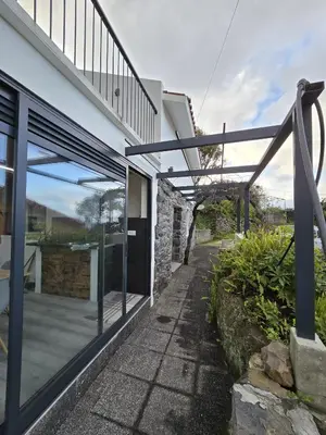 an external view of a house with sliding glass doors at casa Farraia in Santana