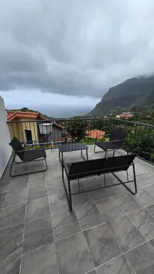 a patio with two chairs and a balcony with a view at casa Farraia in Santana