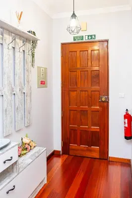 a kitchen with a wooden door and wooden floors at StayinMachico in Machico