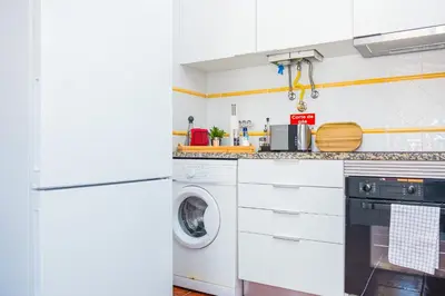 a white kitchen with a washer and dryer at StayinMachico in Machico