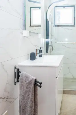 a white bathroom with a sink and a mirror at StayinMachico in Machico