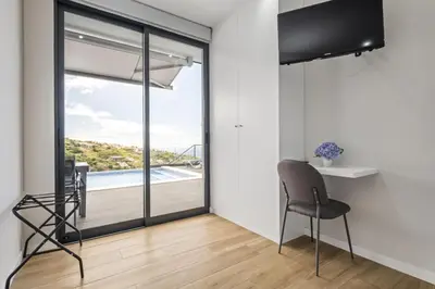 a dining room with a glass door with a view of a pool at Orinoco Sunset House II - Private Pool & Garden in Calheta