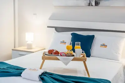 a tray of food on a bed with orange juice at Orinoco Sunset House II - Private Pool & Garden in Calheta