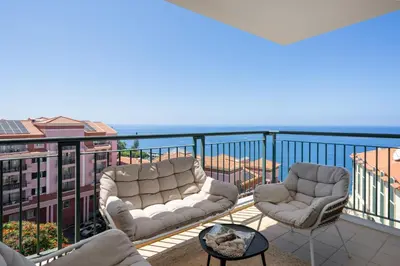 a balcony with two chairs and a view of the ocean at Vila Formosa III by An Island Apart in Funchal