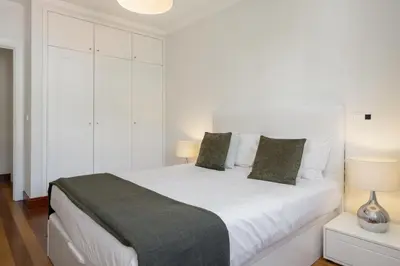 a white bedroom with a large white bed with two lamps at Vila Formosa III by An Island Apart in Funchal