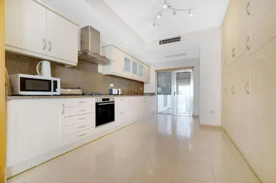 a kitchen with white cabinets and a microwave at Som do Mar Luxury Ocean Front Villa in Luz