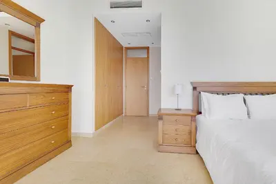 a bedroom with a bed and a dresser with a mirror at Som do Mar Luxury Ocean Front Villa in Luz