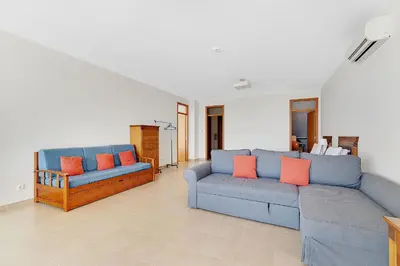 a living room with two blue couches and orange pillows at Som do Mar Luxury Ocean Front Villa in Luz