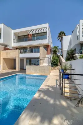 a house with a swimming pool in front of a building at Som do Mar Luxury Ocean Front Villa in Luz