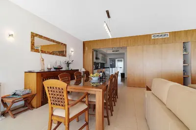 a dining room and living room with a table and chairs at Som do Mar Luxury Ocean Front Villa in Luz