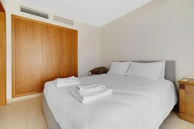 a bedroom with a white bed with towels on it at Som do Mar Luxury Ocean Front Villa in Luz
