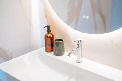 a bathroom sink with a soap dispenser and a mirror at Infinite Sea in Funchal