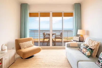 a living room with a couch and a table with a view at Infinite Sea in Funchal