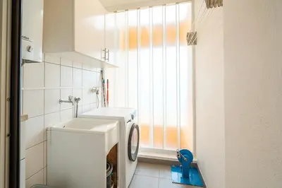a bathroom with a sink and a washing machine at Infinite Sea in Funchal