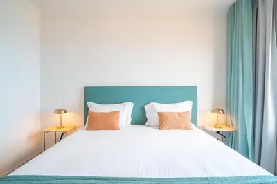 a bedroom with a large white bed with two lamps at Infinite Sea in Funchal