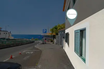 a building with a sign on the side of a street at Luzia by the Sea - T1 Acolhedor a Passos da Praia in Calheta