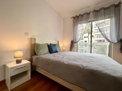 a bedroom with a bed with pink pillows and a window at Pilar - rooms for rent in Funchal