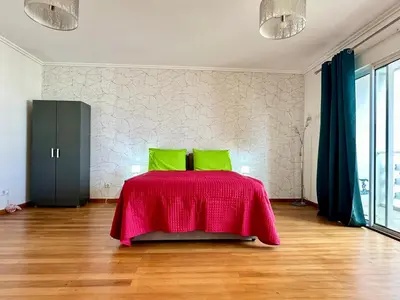 a bedroom with a bed with a red blanket at Pilar - rooms for rent in Funchal