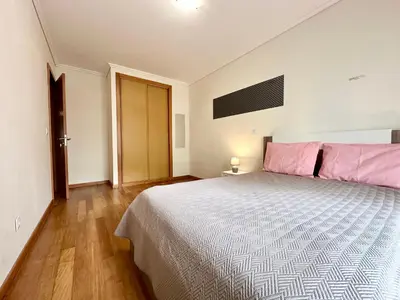 a bedroom with a large bed with pink pillows at Pilar - rooms for rent in Funchal