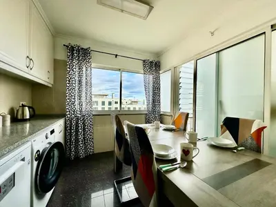 a kitchen with a table with chairs and a dining room at Pilar - rooms for rent in Funchal