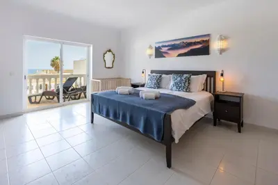 a bedroom with a large bed and a balcony at Apartment do Ramses in Luz