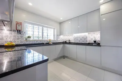 a kitchen with white cabinets and black counter tops at Apartment do Ramses in Luz