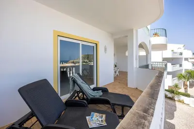 a living room with chairs and a balcony at Apartment do Ramses in Luz