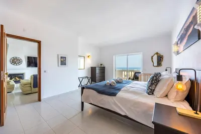 a bedroom with a large bed and a living room at Apartment do Ramses in Luz