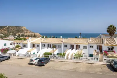 a row of houses with the ocean in the background at Apartment do Ramses in Luz