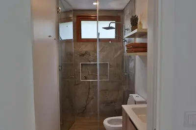 a bathroom with a shower with a toilet and a sink at Refúgio da Ribeira in São Vicente