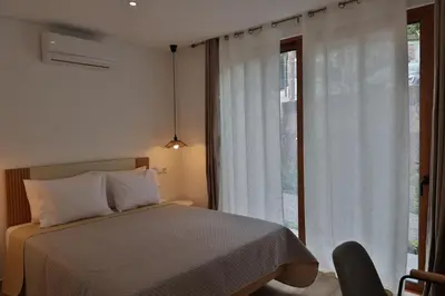 a bedroom with a bed and a large window at Refúgio da Ribeira in São Vicente