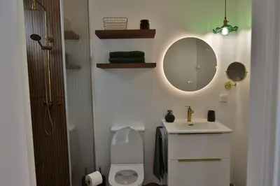 a bathroom with a sink and a toilet and a mirror at Refúgio da Ribeira in São Vicente