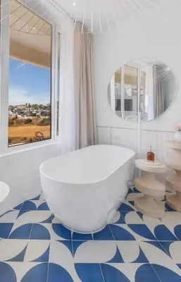 a large white tub in a bathroom with a window at Ocean Apartment by ENDLESS SUN I modern comfort, sea view, wi-fi, parking, heating in Lagos